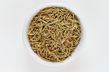 Dried rosemary herb in white dish 