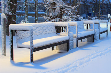 Park benches covered with the first snow