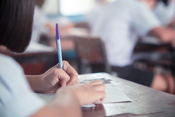 Student doing test or exam  in classroom of school with stress