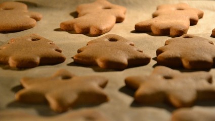 Christmas cookies. Homemade gingerbread cookies in various shapes  on the baking tray. Cookies freshly made at home, golden browned colored cookies before decorating with icing