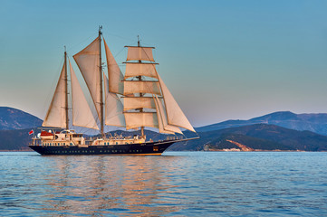 Sailing ship under white sails at the regatta. Yachting sport competition