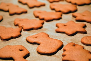Christmas cookies. Homemade gingerbread cookies in various shapes  on the baking tray. Cookies freshly made at home, golden browned colored cookies before decorating with icing