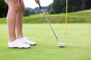 Obraz premium Golfer putting golf ball on the green golf