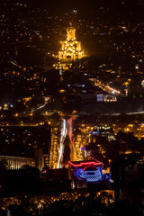 Tbilisi, Georgia A scenic view at night of the city and the illuminated Holy Trinity Cathedral of Tbilisi