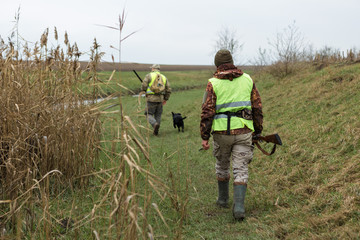 Hunting period, autumn season open. A hunter with a gun in his hands in hunting clothes in the...