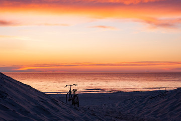 Bicycle on the beach at sunset