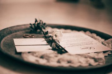close up.wedding invitations and wedding rings on a silver tray