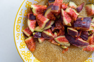Gluten free amaranth porridge for breakfast with figs in a yellow bowl top view