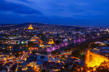 Naklejka premium Tbilisi, Georgia The city at dusk and the Holy Trinity Cathedral of Tbilisi in the background and the Narikala Fortress.