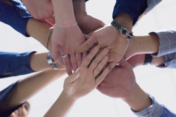 College Students Teamwork Stacking Hand Concept. Close up of young people putting their hands together. Friends with stack of hands showing unity and teamwork.