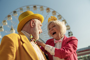 Happy old couple in ridiculous clothes having fun outdoors