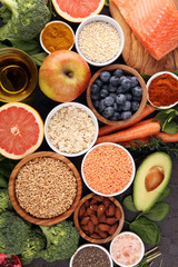 Healthy food clean eating selection: fish, fruit, vegetable, cereal, leaf vegetable on rustic background