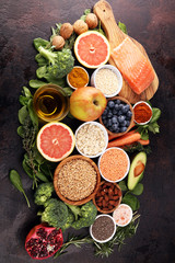 Healthy food clean eating selection: fish, fruit, vegetable, cereal, leaf vegetable on rustic background