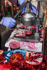 Tbilisi, Georgia A woman presses pomogranates into juice at the busy fruit and vegetable market at Station Square.
