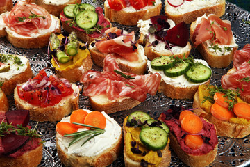 Assorted bruschetta with various toppings. Appetizing bruschetta or brie crostini. Variety of small sandwiches. Mix bruschetta on table