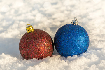 Blue and red Christmas baubles on the snow
