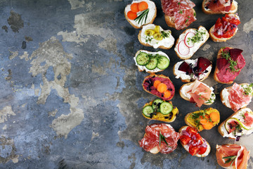 Assorted bruschetta with various toppings. Appetizing bruschetta or brie crostini. Variety of small sandwiches. Mix bruschetta on table