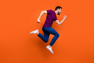 Fototapeta na wymiar Full length body size photo side profile of urgent man running towards shopping center in blue pants foot wear jumping isolated vivid color background