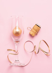 New Year or Christmas layout balls balls Serpentine cork from a bottle of gold color pink background. Holiday concept.