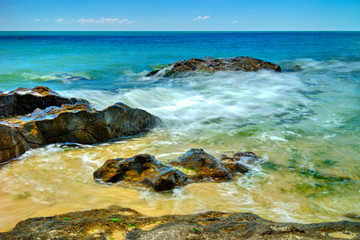 Beautiful landscape with rocks and sea waves on a sunny beach