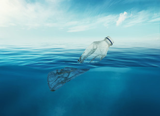 a discarded plastic rubbish bottle floats underwater on a presenting a hazard to all marine life 