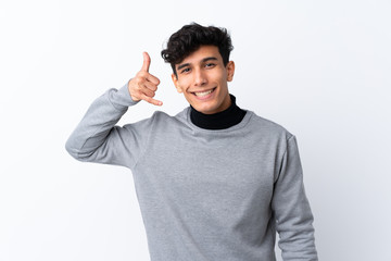 Young Argentinian man over isolated white background making phone gesture. Call me back sign