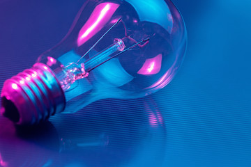 Photo of light bulb lamp in neon light. Ideea concept.