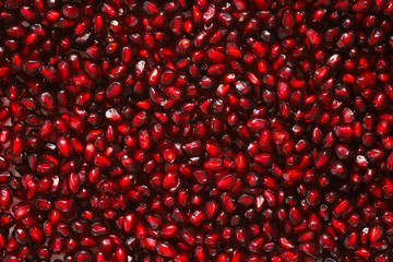 Fresh red seeds of pomegranate. Food pattern texture background. Organic super food.