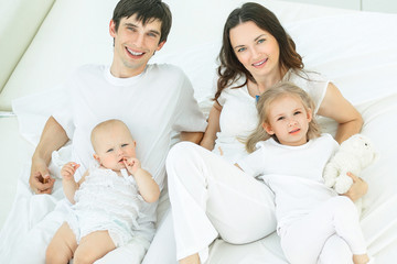 Obraz premium portrait of a happy family on the bed in the bedroom