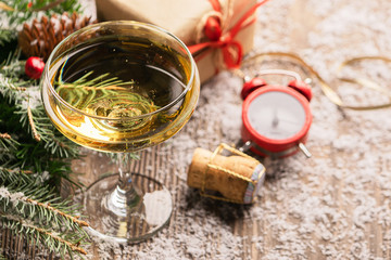 A glass of champagne sparkling wine cork clock close-up on a festive decorated table. Christmas New Year concept.