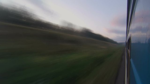 Traveling by passenger train at sunset timelapse. View from the train window.