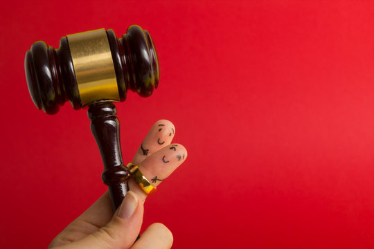 Purposal devorce creative concept. Painted happy fingers smiley in love against red background with court libra