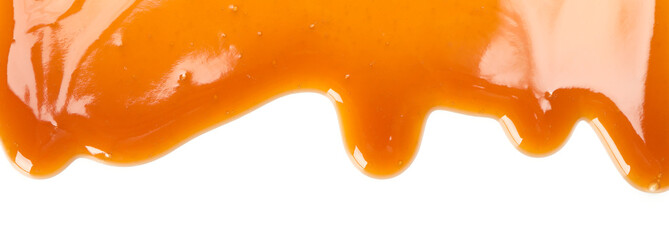 Flowing caramel sauce isolated on white background, close up
