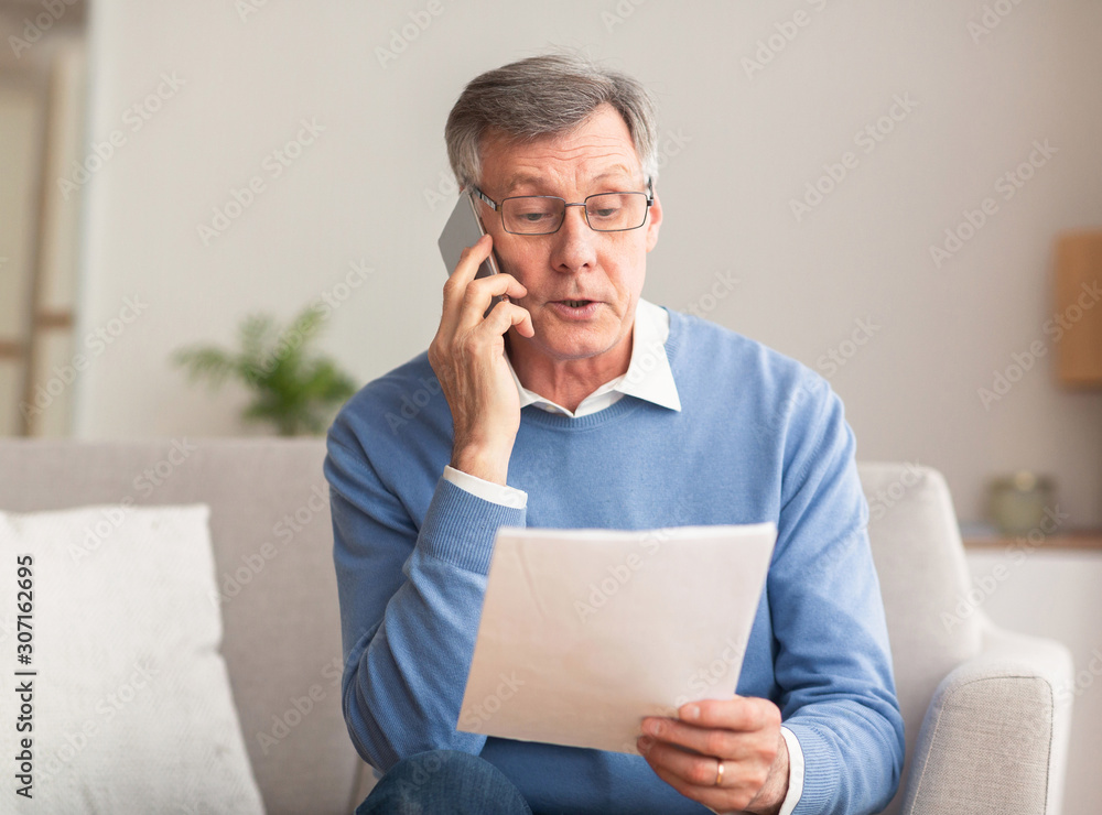 Wall mural Senior Entrepreneur Talking On Phone Working Sitting On Sofa