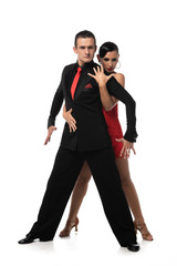 expressive, elegant dancers looking at camera while performing tango on white background
