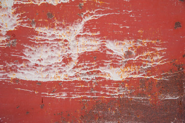Streaks of white paint on an old, red, rusty, tattered metal surface. Abstract background, texture.