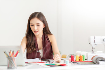 Young woman Fashion Designer is working with laptop computer.