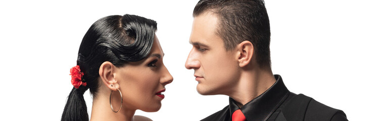 panoramic shot of sensual dancers looking at each other while performing tango isolated on white
