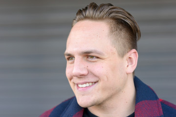 Fototapeta premium Handsome young man looking aside with a smile
