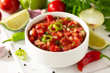 Traditional mexican homemade salsa sauce and ingredients on a white wooden table. - obrazy, fototapety, plakaty