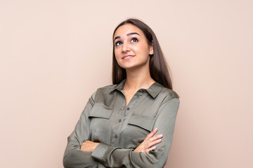 Young girl over isolated background looking up while smiling