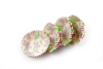 Paper, disposable muffin baking dish with a delicate floral pattern, shot on a white background