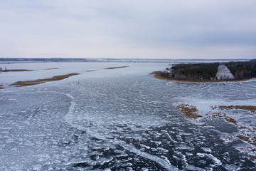 Winter landscape. The river beneath a thin , patterned ice. The view from the top. Shooting from a...
