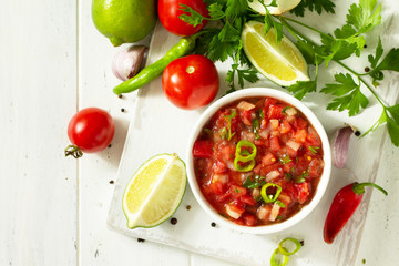 Traditional mexican homemade salsa sauce and ingredients on a white wooden table. Top view on a flat background. Copy space. - obrazy, fototapety, plakaty