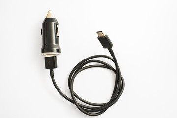 black car charger with USB output connection cable. A photo taken on a black car charger with USB output connection cable against a white backdrop