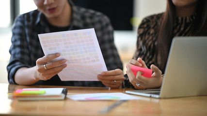 Cropped shot graphic design they meeting project on table with laptop.