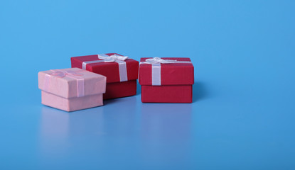 Obraz premium Three gift boxes placed on the blue floor with two red gift boxes and one blue box gift.