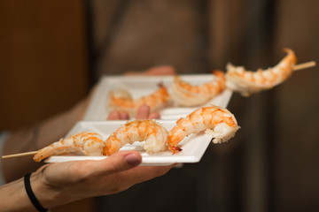 Close up of a grilled giant shrimps brochette on a white plastic plate, Nishiki Market, Kyoto, Japan