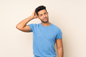 Young handsome man over isolated background having doubts while scratching head