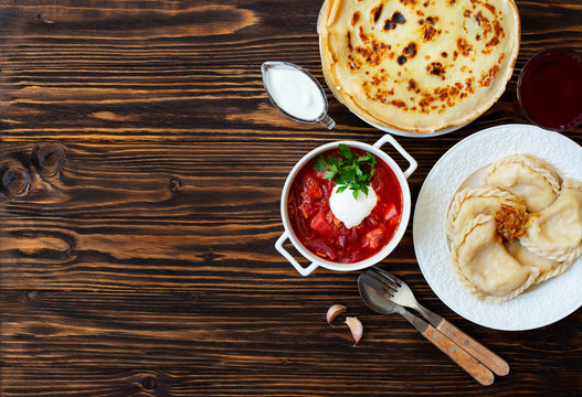 The Concept Of Eastern European National Cuisine. Ukrainian, Russian, Polish Food.Traditional Beetroot Soup Borscht With Sour Cream, Pancakes Blini, Dumplings Vareniki With Potatoes And Fried Onions